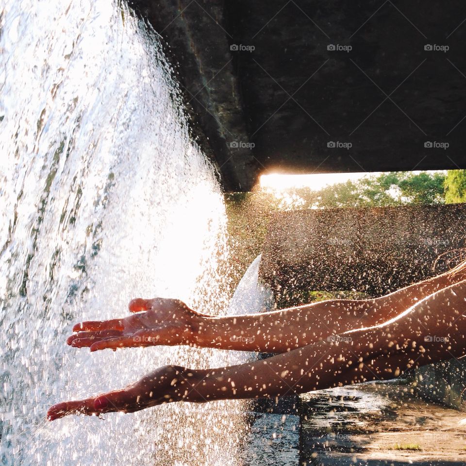 Close-up of person hand with waterfall