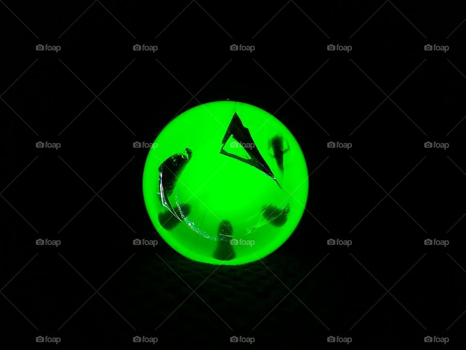 Glass ball illuminated with green light.
