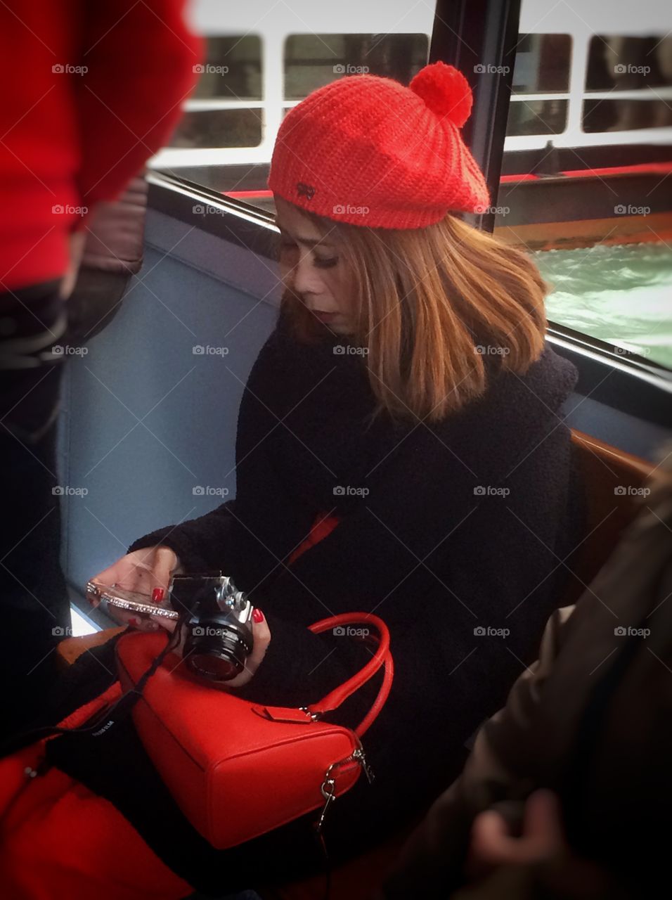 Woman sitting with mobile phone and camera in hand