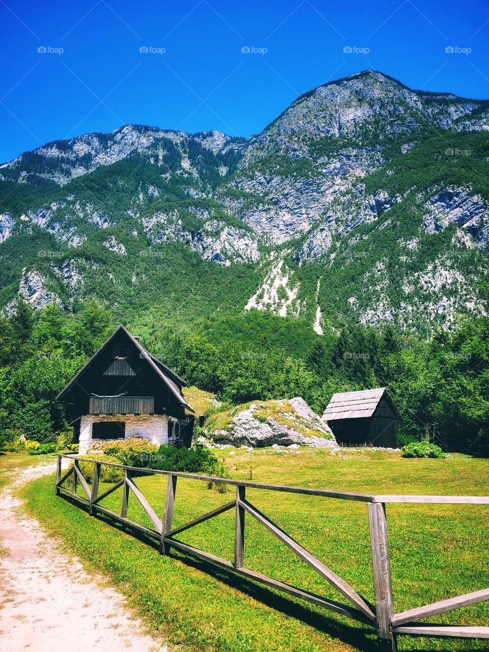 Scenic view of green Alps mountains against blue sky and beautiful lake in Slovenia. Summer time. Vacation. Landscape