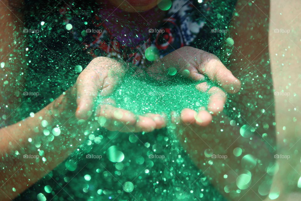 Close-Up Of person blowing glitter
