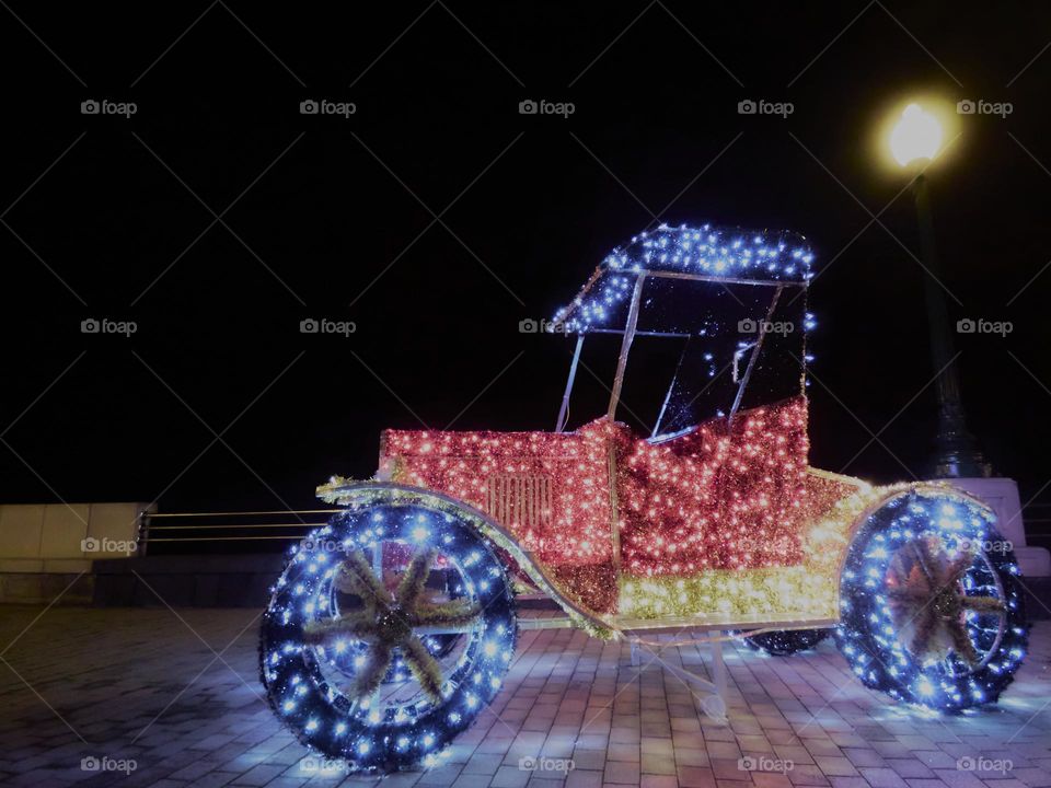 coche antiguo con luces de navidad de colores tomada de noche en un paseo solitario