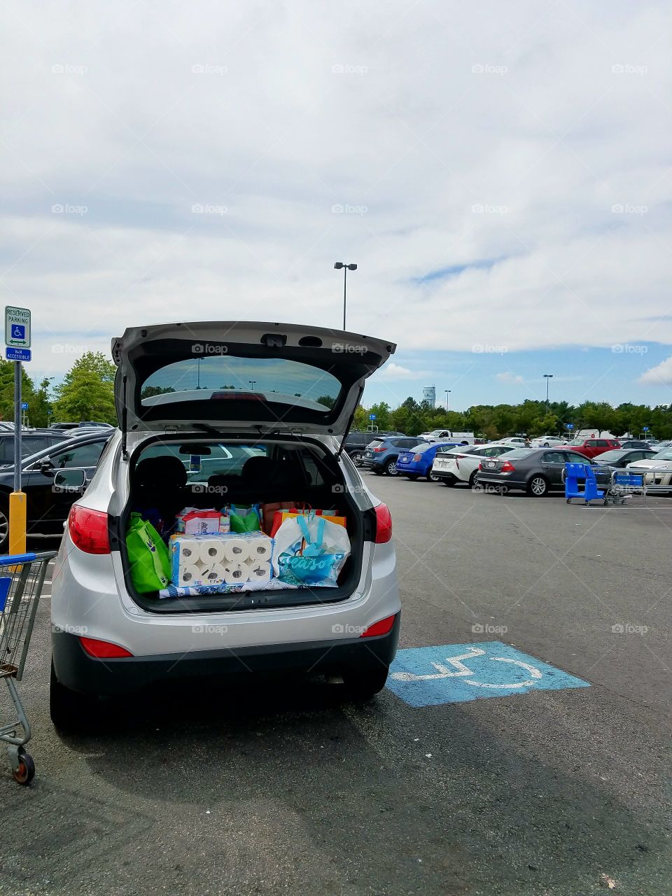Shopping in large chain grocery store. Cars in huge parking lot.