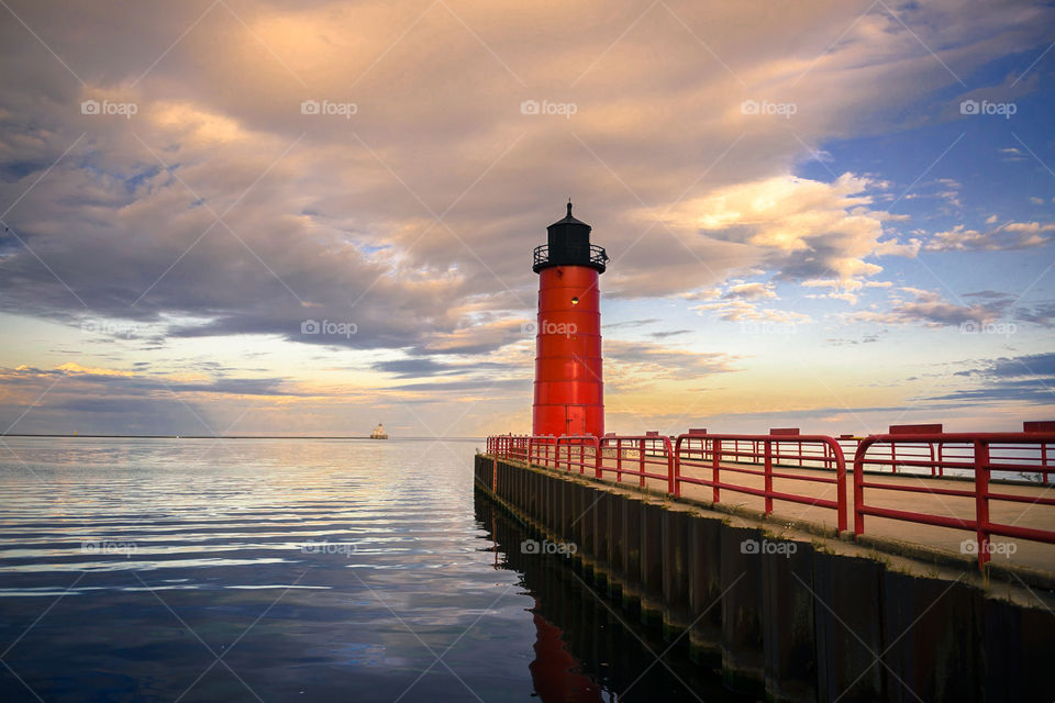 Sunrise on Lake Michigan in Milwaukee Wisconsin with a red light house