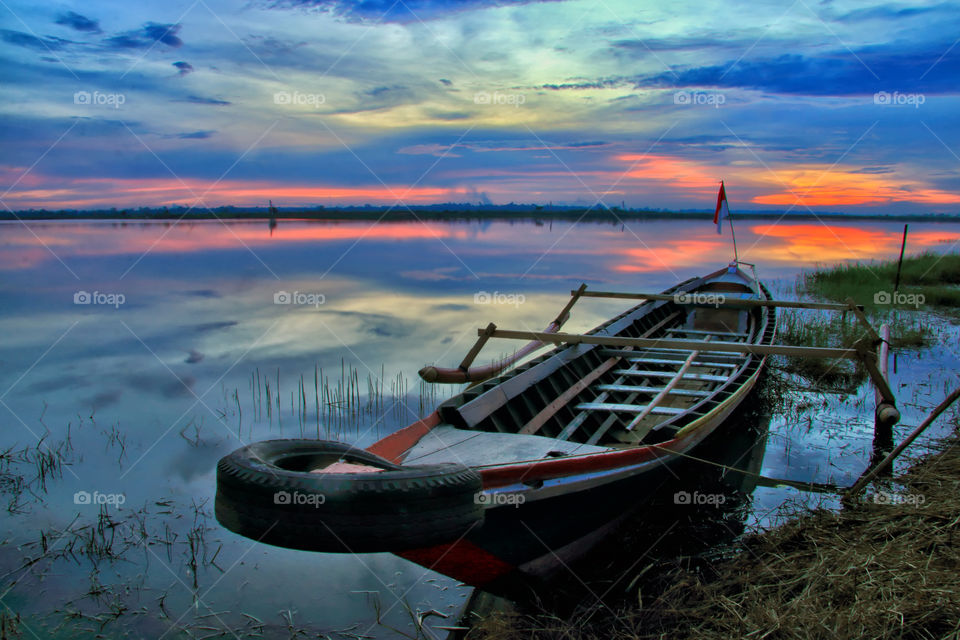 Alone Boat under Sunset at Galuh Cempaka Lake, South Borneo, Indonesia.