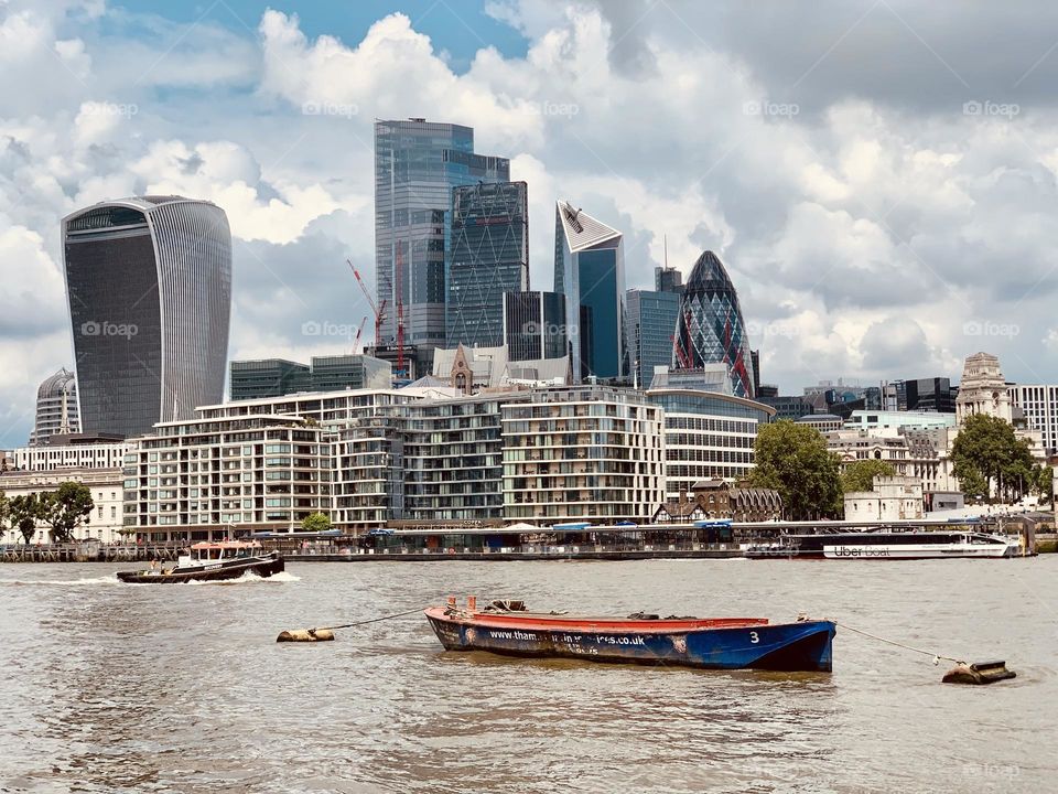 View of London business quarter, modern building skyscrapers, Thames river with boats, glimpse of London 