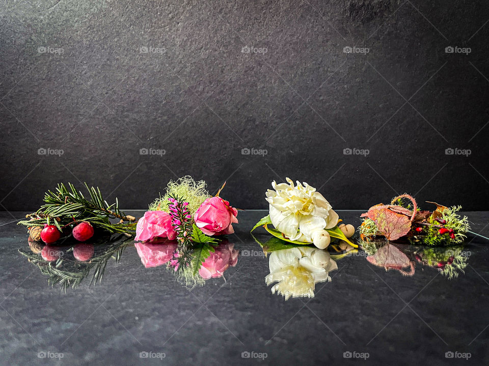 The four seasons - winter, spring, summer, and fall - represented in Pacific Northwest foliage including evergreens, pine needles, berries, flowers, and leaves. 