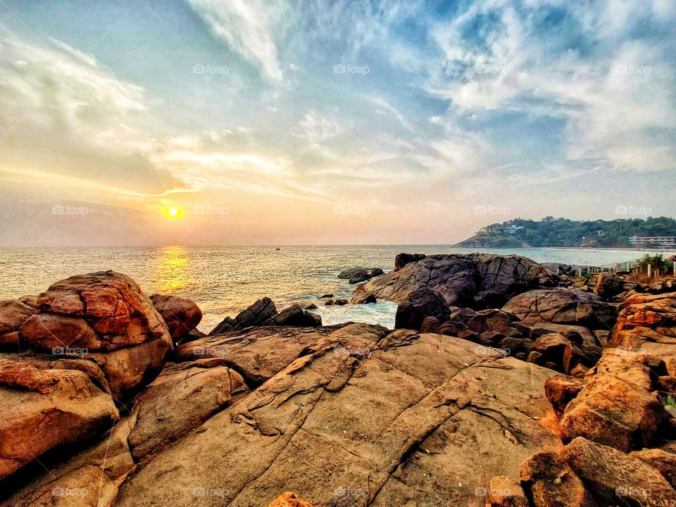 What a stunning view! The sun setting over those rocks looks so peaceful and beautiful. Nature never fails to amaze me! 🌅✨