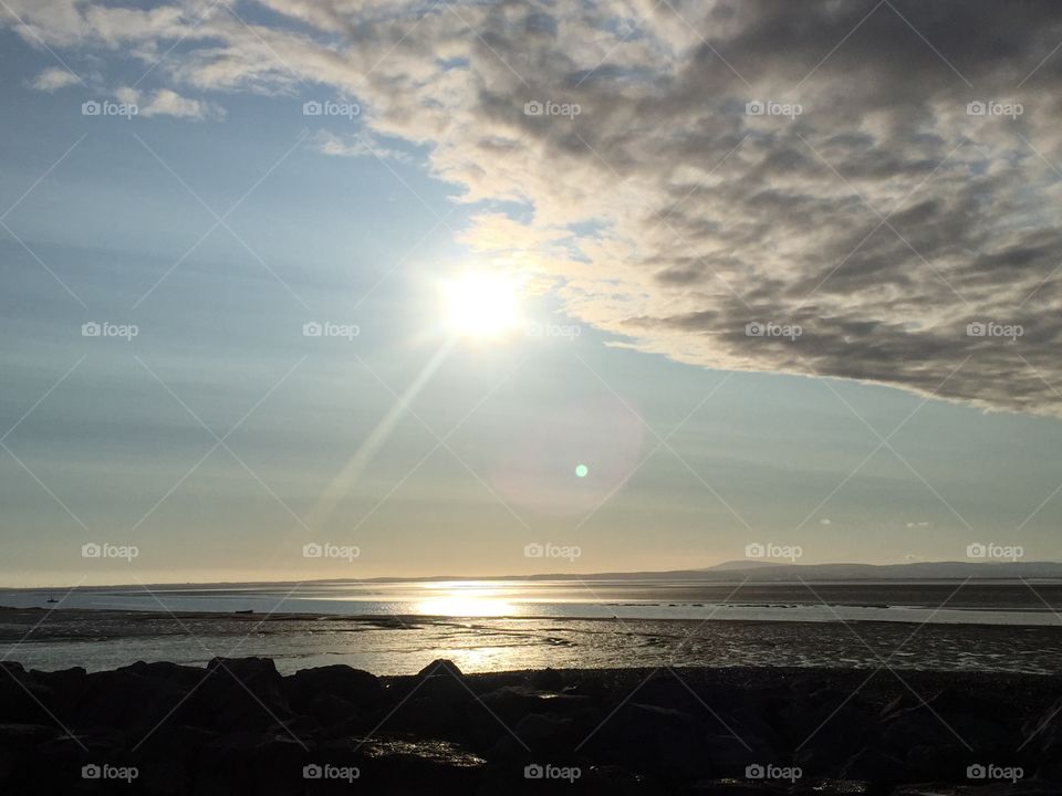 John Smalley . Sun coming from behind cloud at morcambe sea front 