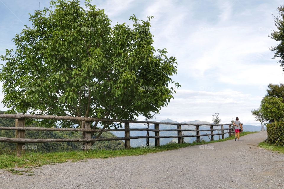 Woman walking on a mountain path in summer time 
