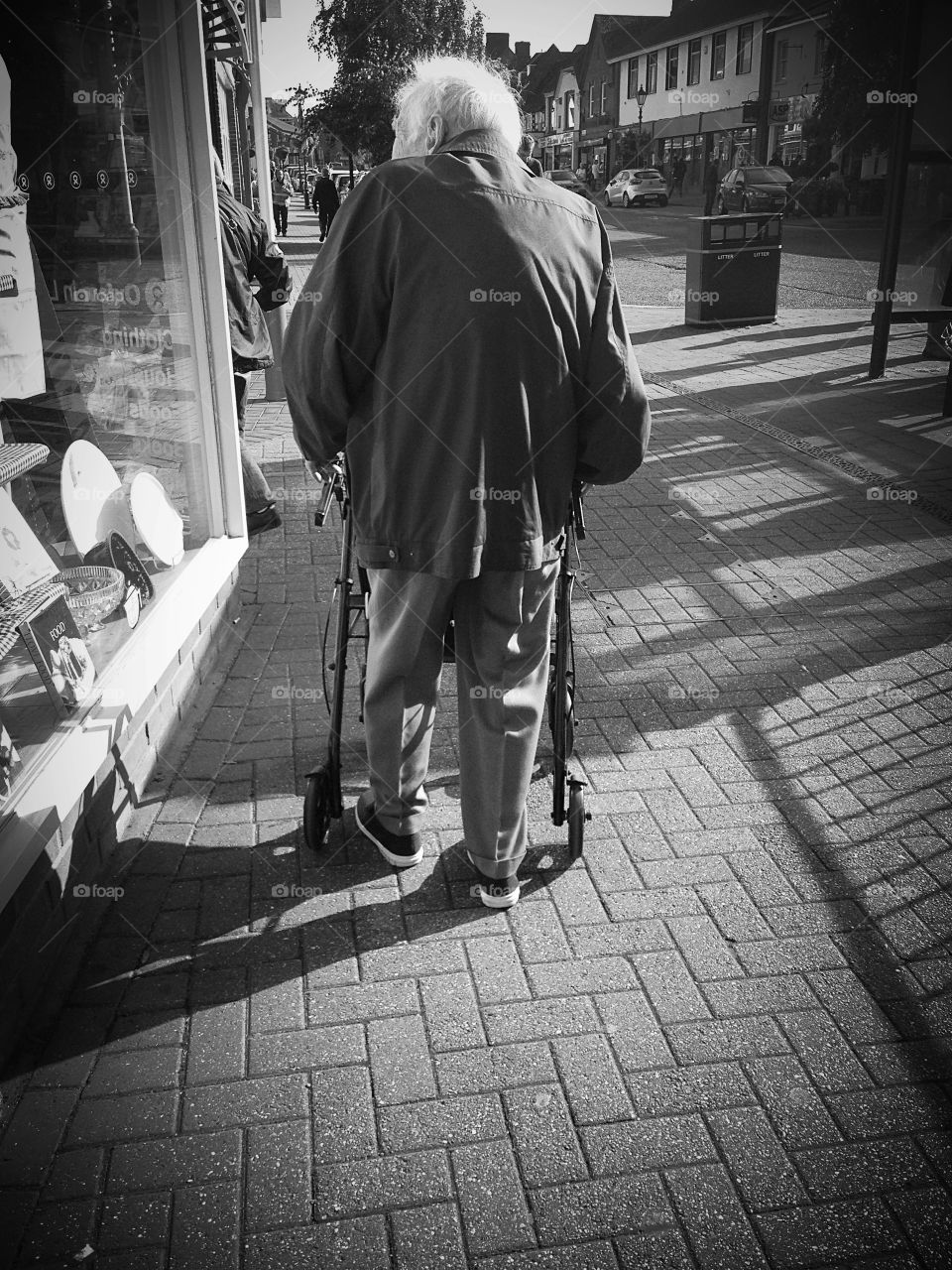 Elderly man walking alone on an English high street