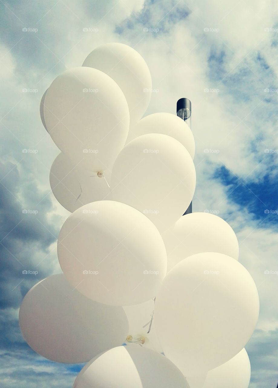 White balloons on the background of a summer stormy sky