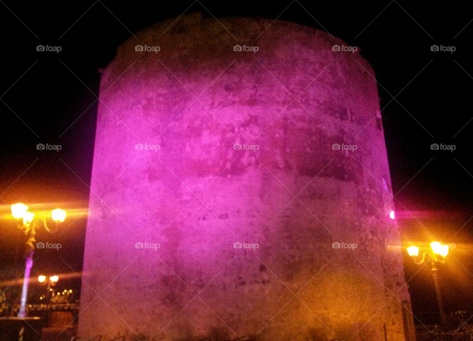 old fortified tower illuminated by pink light - Sardinia