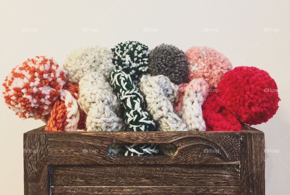 Crate full of crocheted Pom Pom beanies