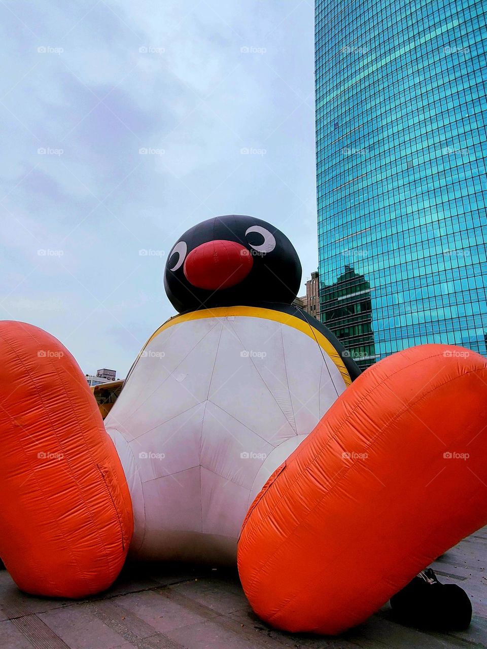 Penguin Bigfoot appears next to high-rise buildings