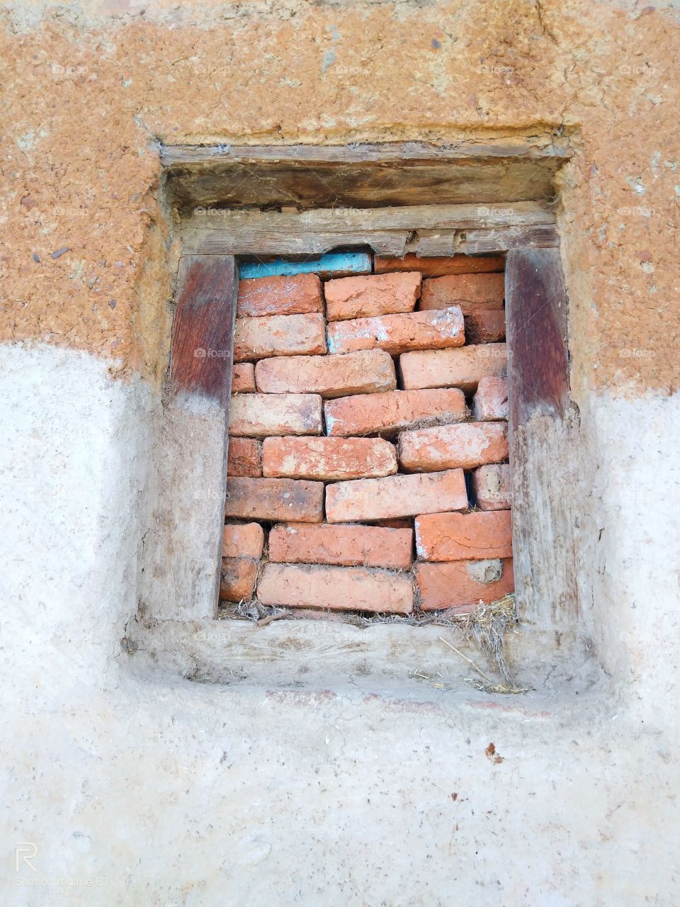 wooden window that is closed with bricks