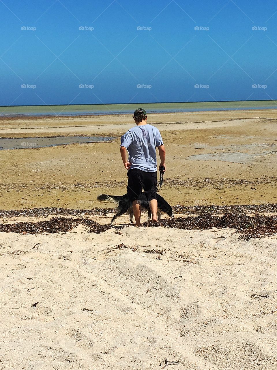 My son walking Peter our border collie on the beach at low tide on south Australia 