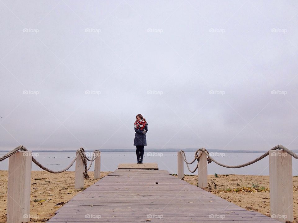 Young woman standing on board walk at beach