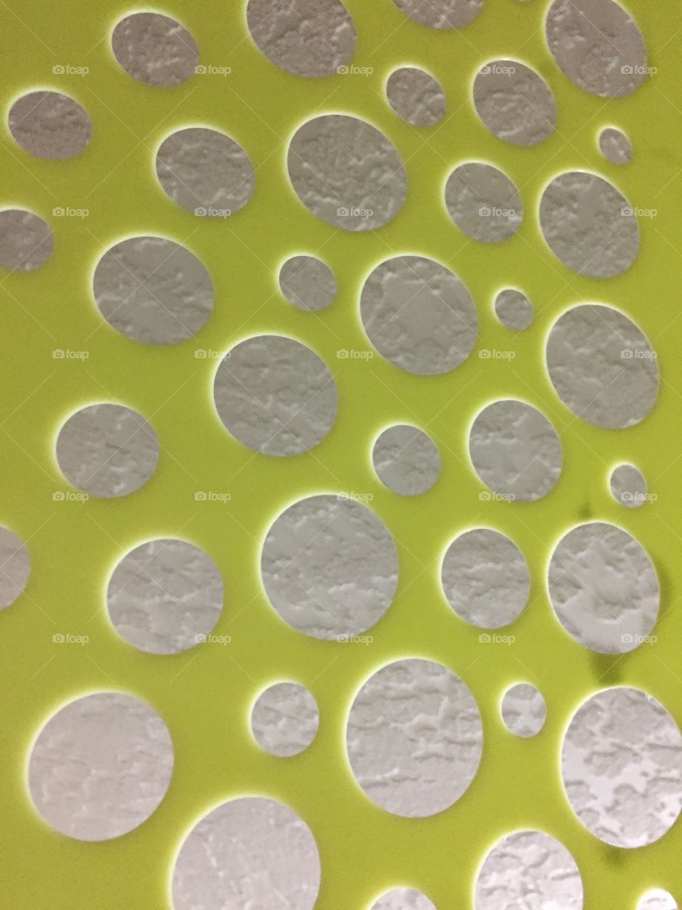 An abstract with rough white circles and smooth green surrounding surface. Look from different angles and the perspective changes. 