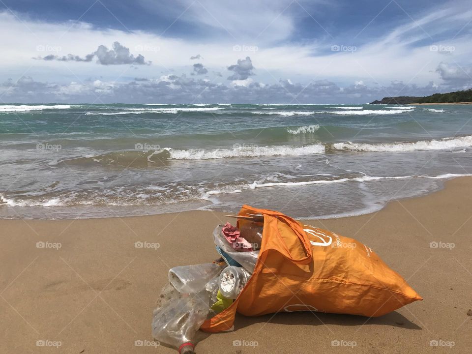 Beach cleanup bag in front of ocean