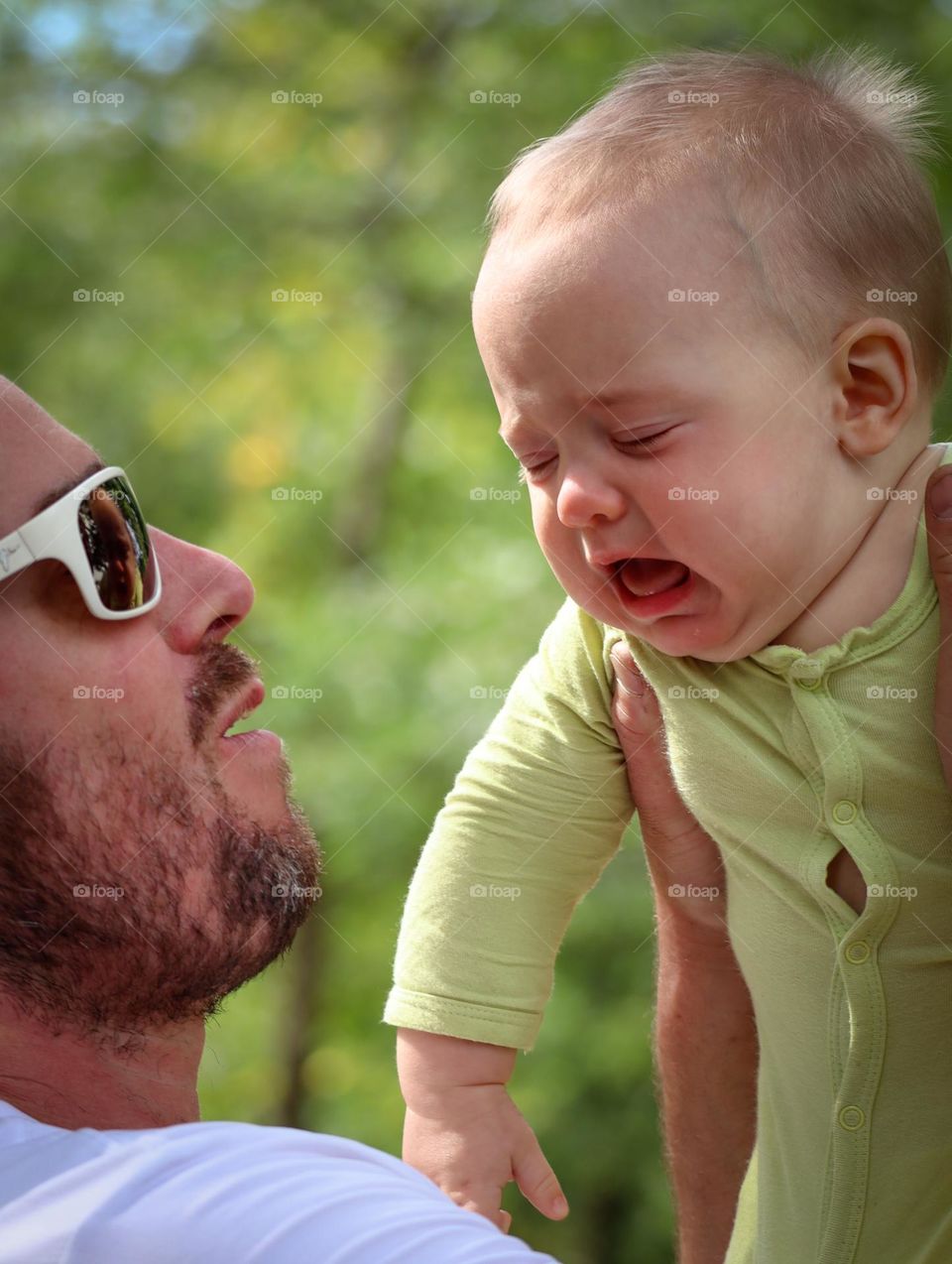 Crying cute baby and his father