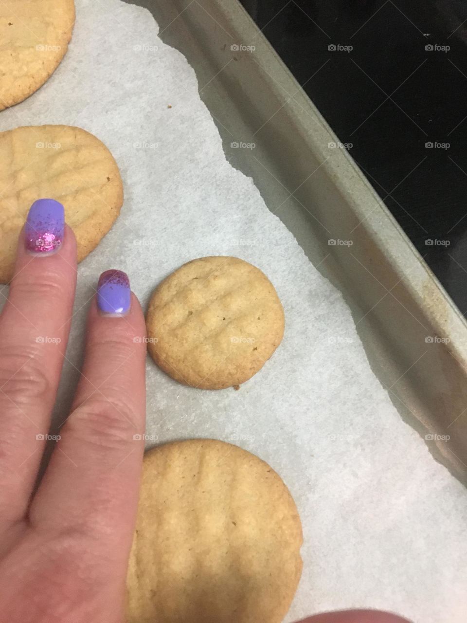 Lady showing how small her cookie is with her fingers
