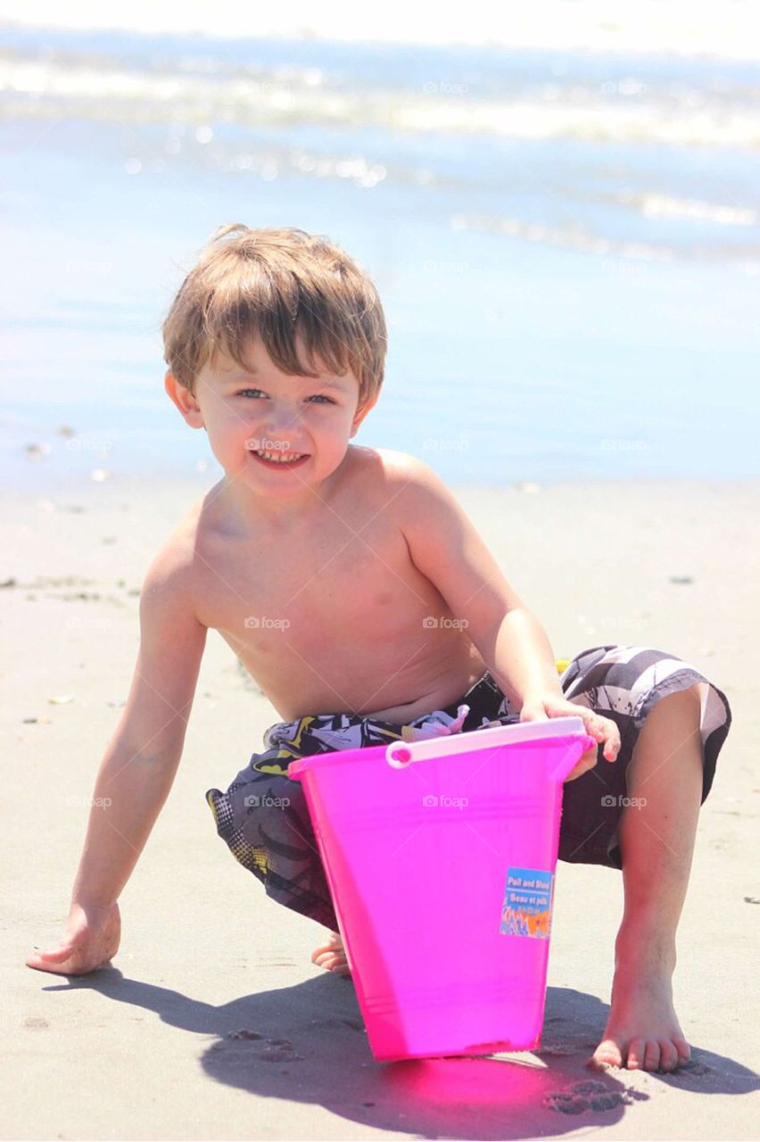 Small little boy plating at beach