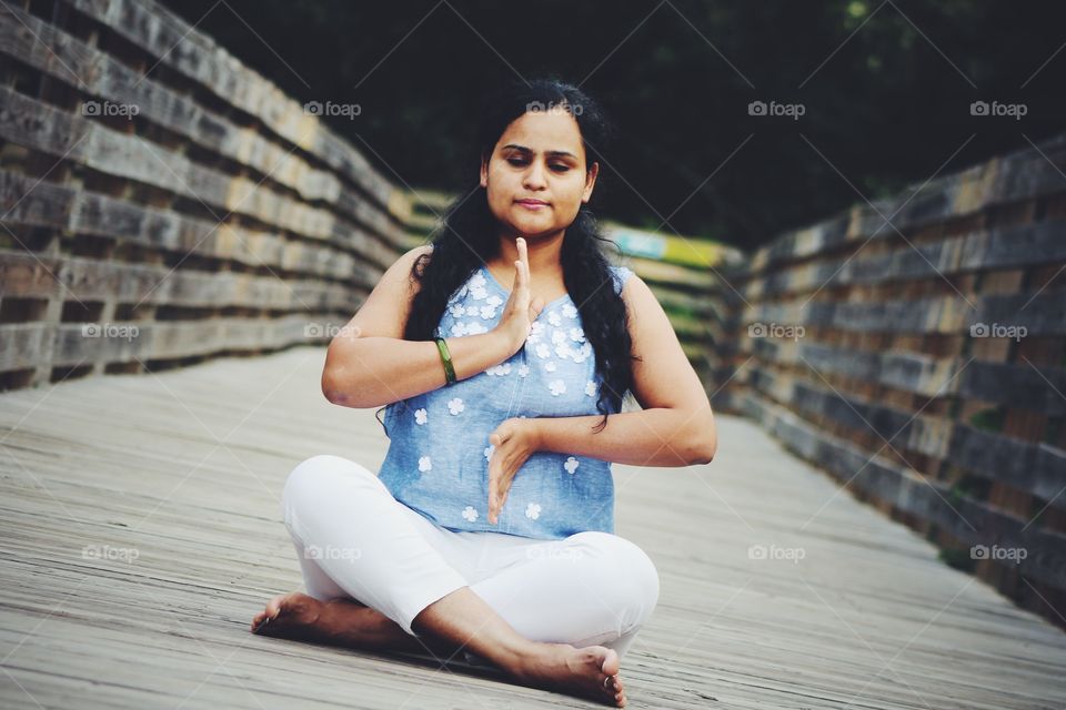 Woman practicing yoga at boardwalk