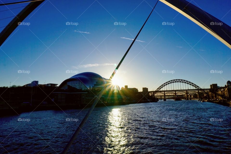 Newcastle sunset ... sun rays bouncing off The Sage and lighting up the Tyne ... with the High Level bridge partly visible in the distance 