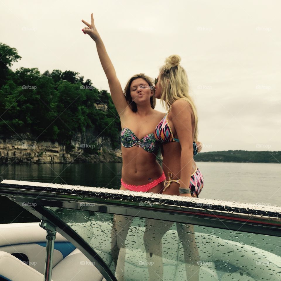 Two women in bikini on boat at lake