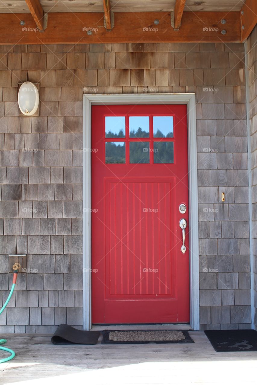 Red door white trim and shake siding