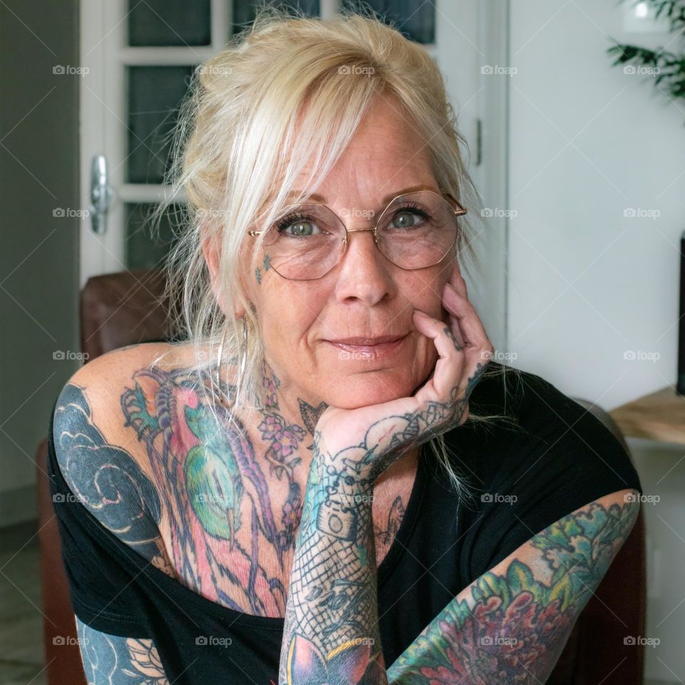 portrait of blonde tattoed middle aged woman