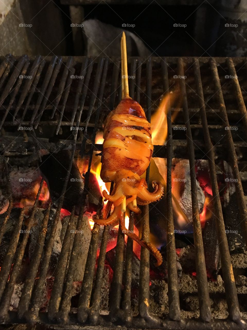 Flaming squid on a skewer in Thai night market