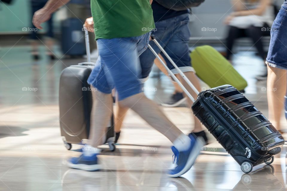 People walking with luggage at the airport, rush hour