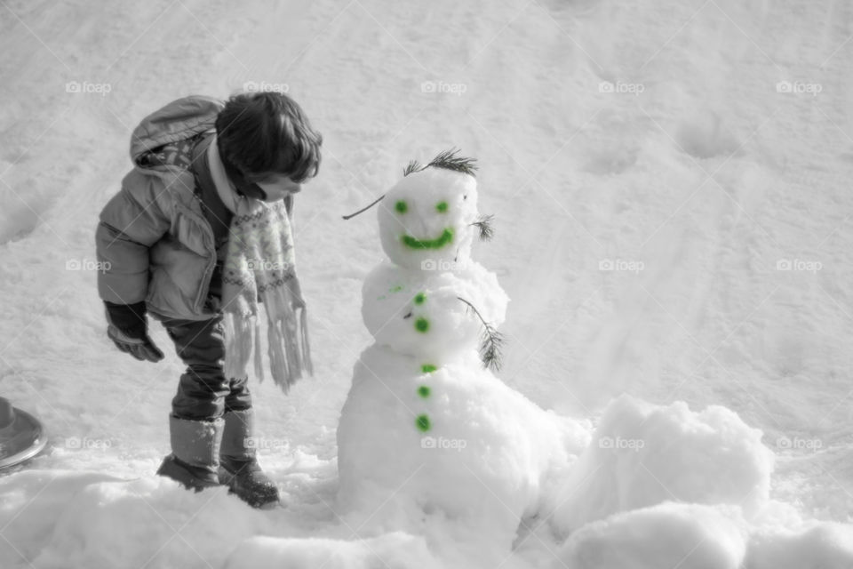 Little kid playing with Snowman