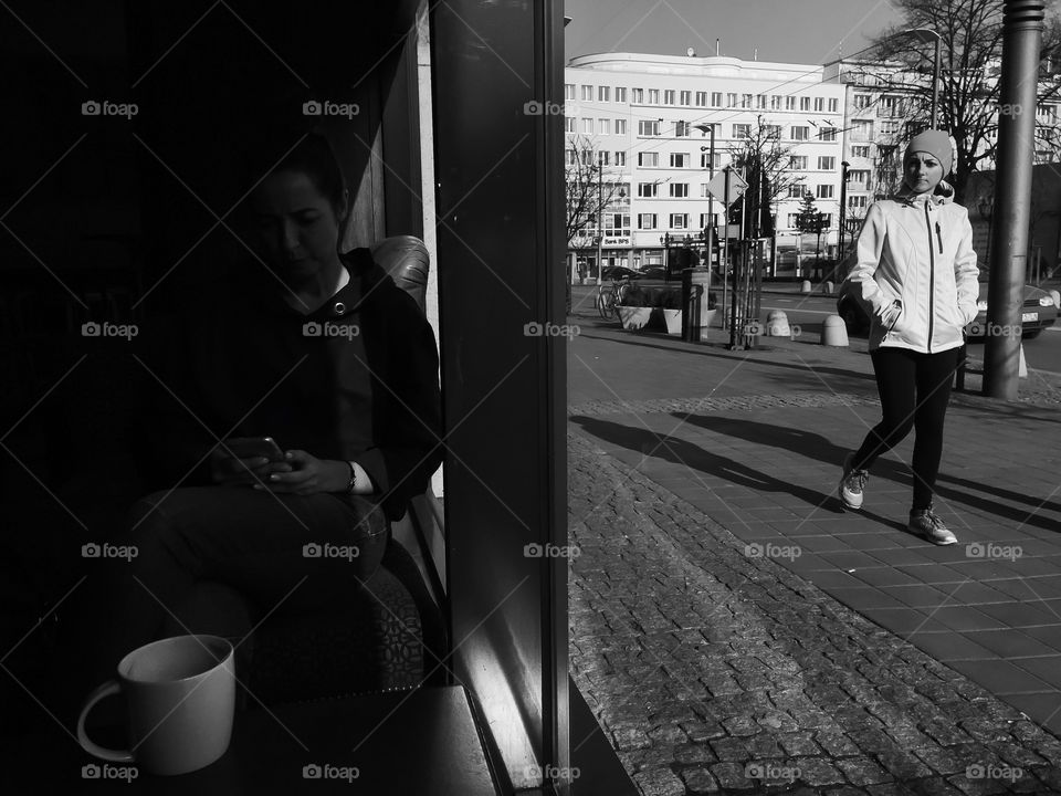 Woman walking on walkway in city