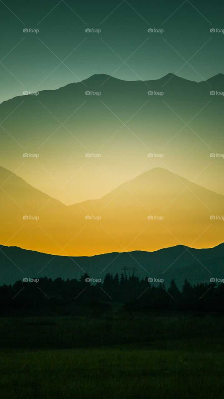 An inspiring mountain landscape. Tatry mountains in Slovakia. A beautiful wallpaper for smartphone screen. Warm summer haze, abstract gradient with perspective.