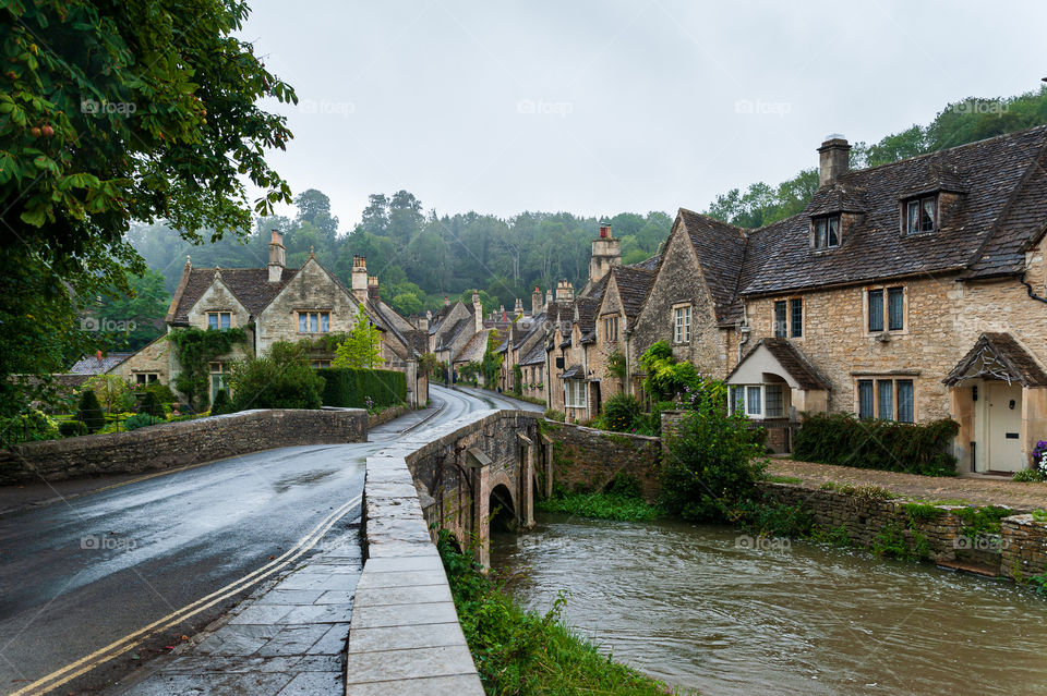 Step back in time. Castle Combe a quaint English village in Wiltshire countryside on rainy day. No new houses built since circa 1600 century. UK.