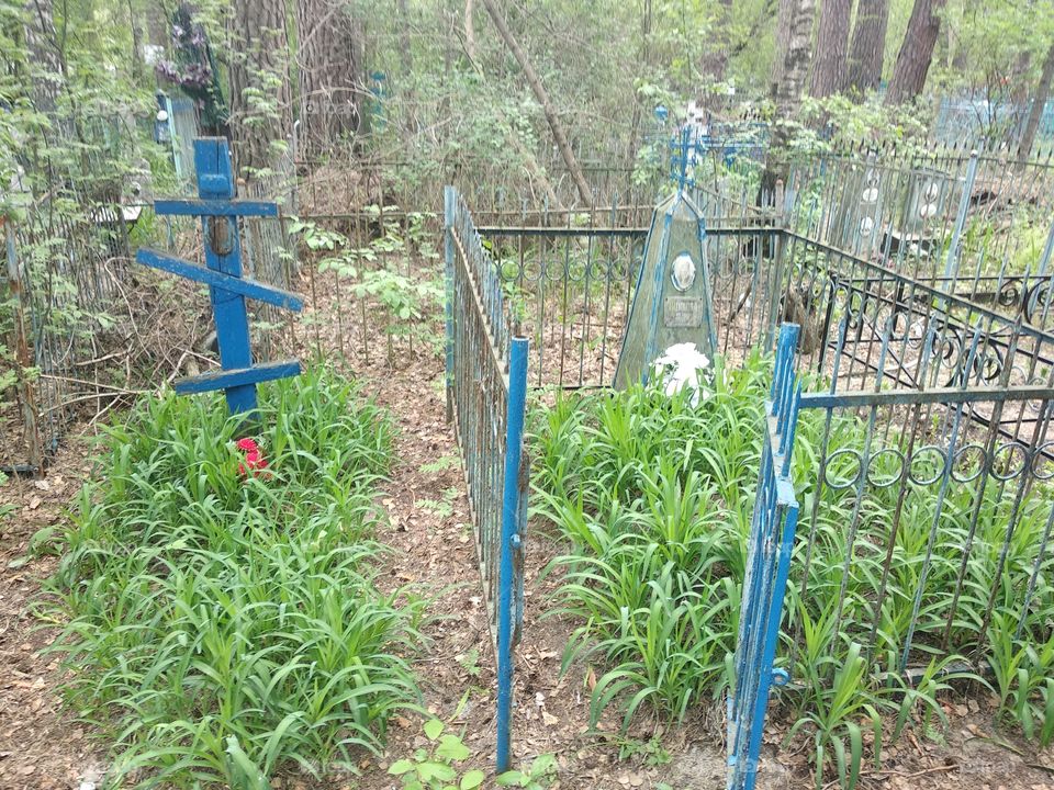 An old blue wooden cross on an abandoned grave in a cemetery in Russia