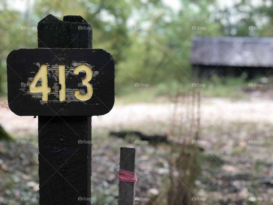 Sign 413 in front of Log Cabin