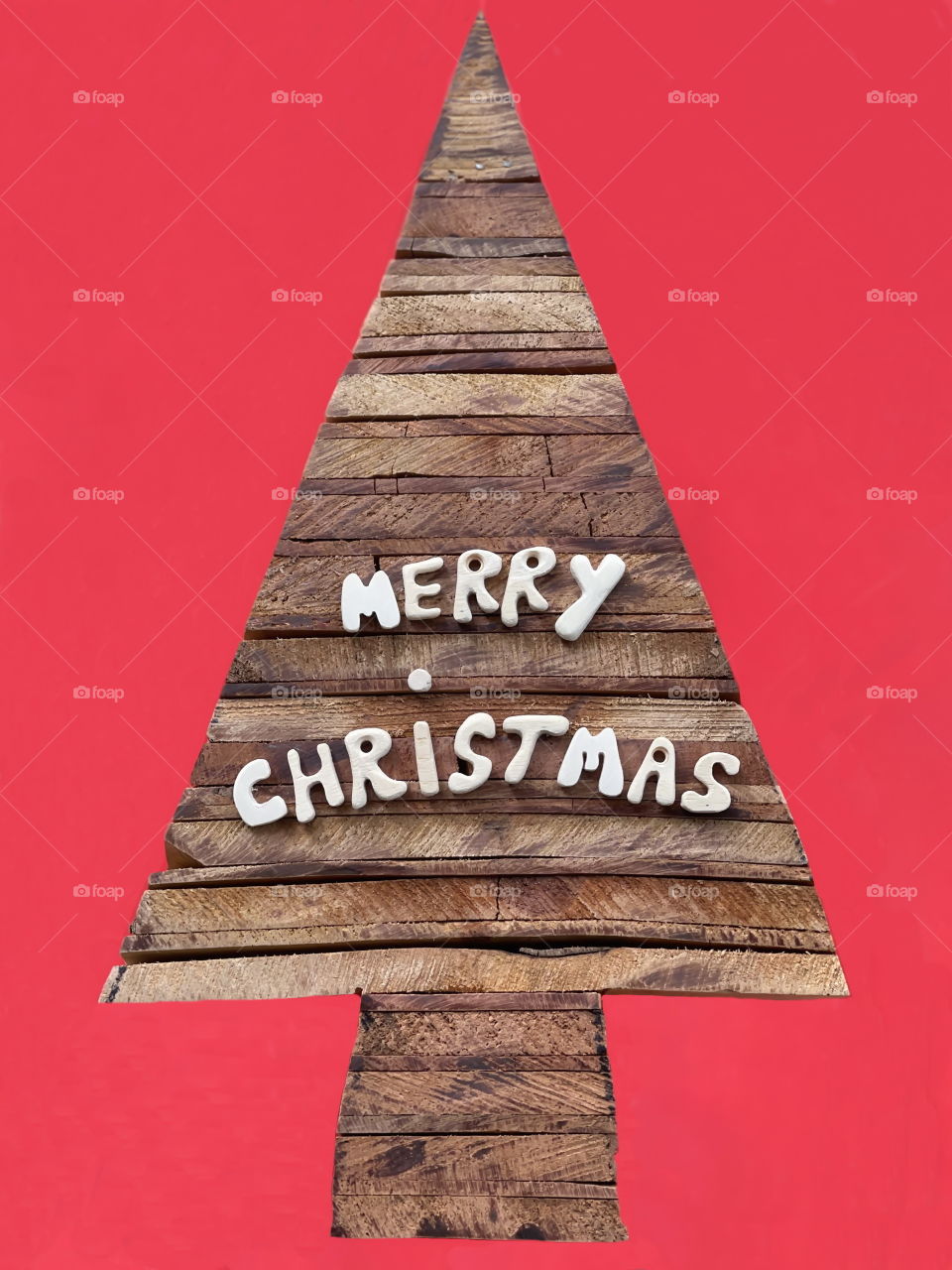 Merry Christmas message with a composition of wooden letters over a stylized wooden Christmas tree