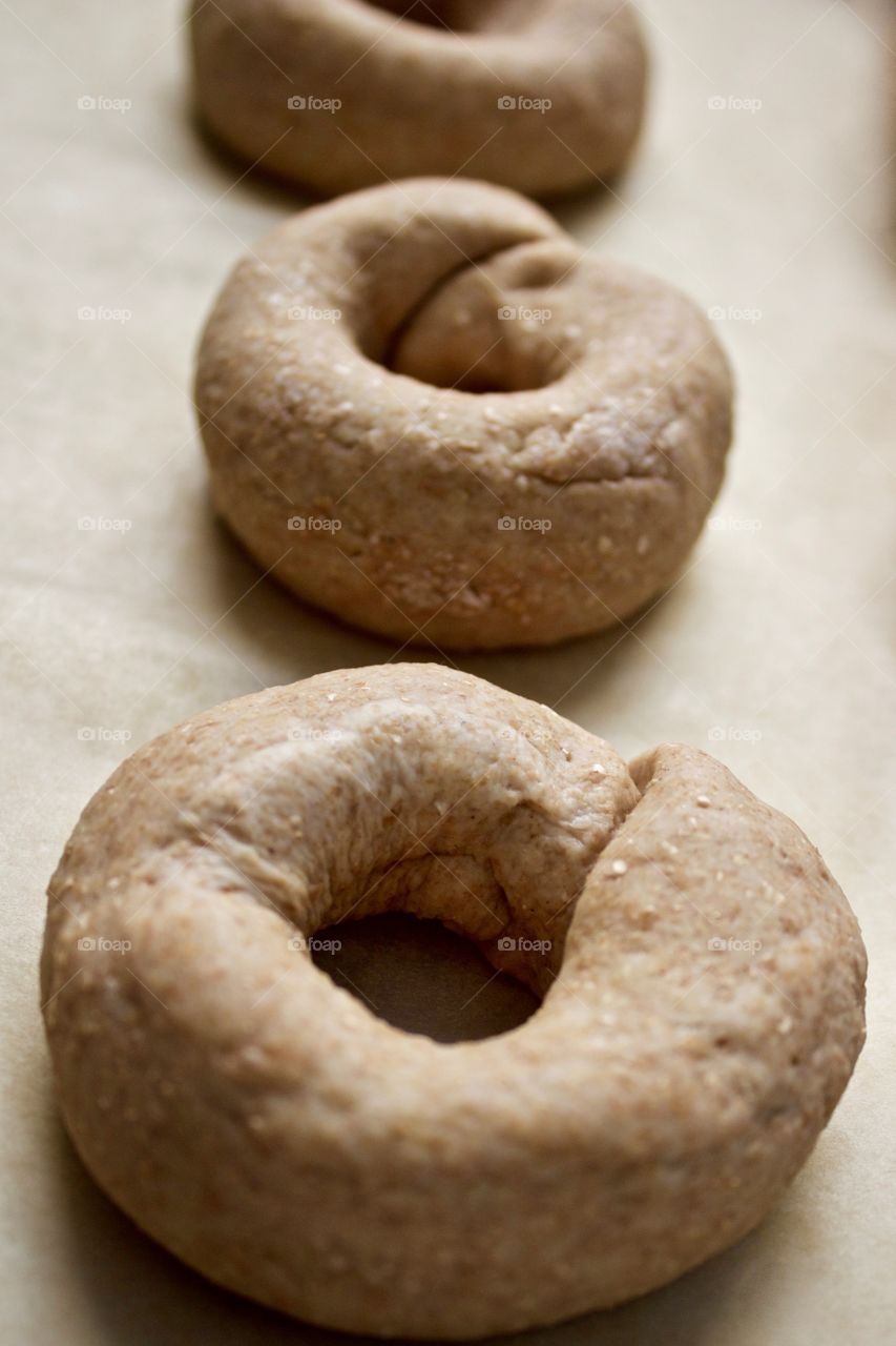 Angled closeup of sourdough spelt and whole wheat dough for bagels on parchment paper