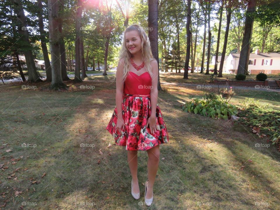 Girl is bright red and floral dress