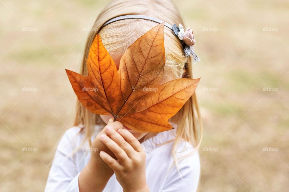 Happy kid with maple leaf outdoor 