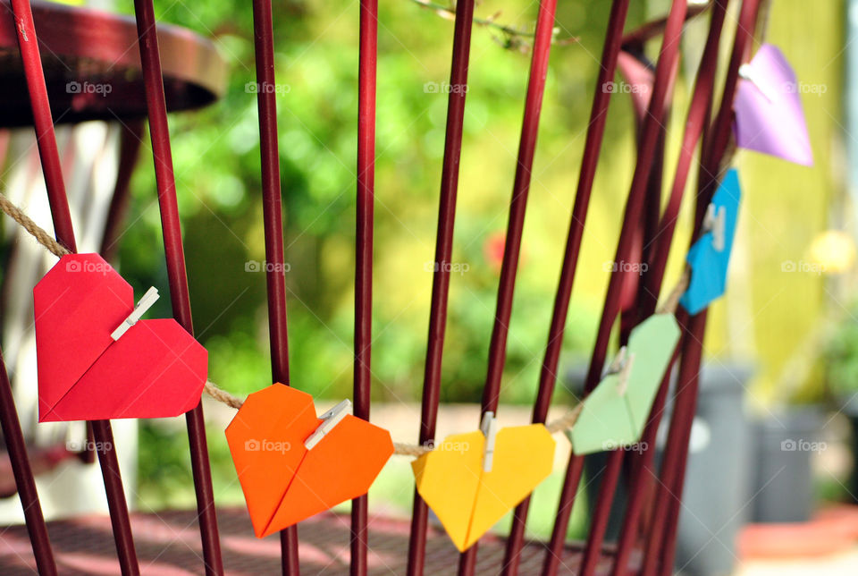 Macro shot, hearts hanging, clips, metal bars, rainbow, rope