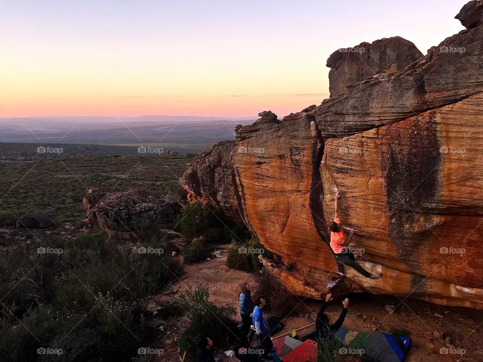 Sunset climbing session. Rock climbers support each other in a boulder in the sassies area of the Rocklands in South Africa at sunset. 