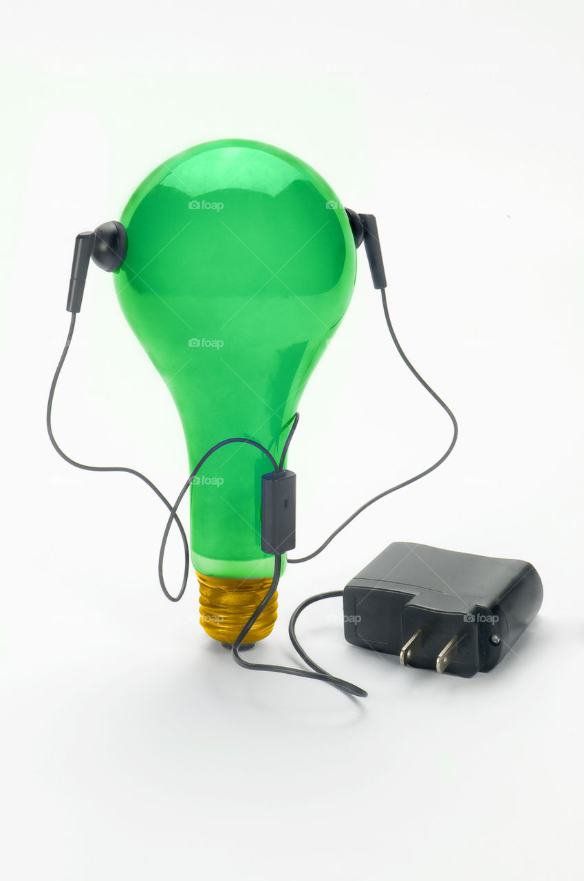 Green light bulb With headphone and connector White background