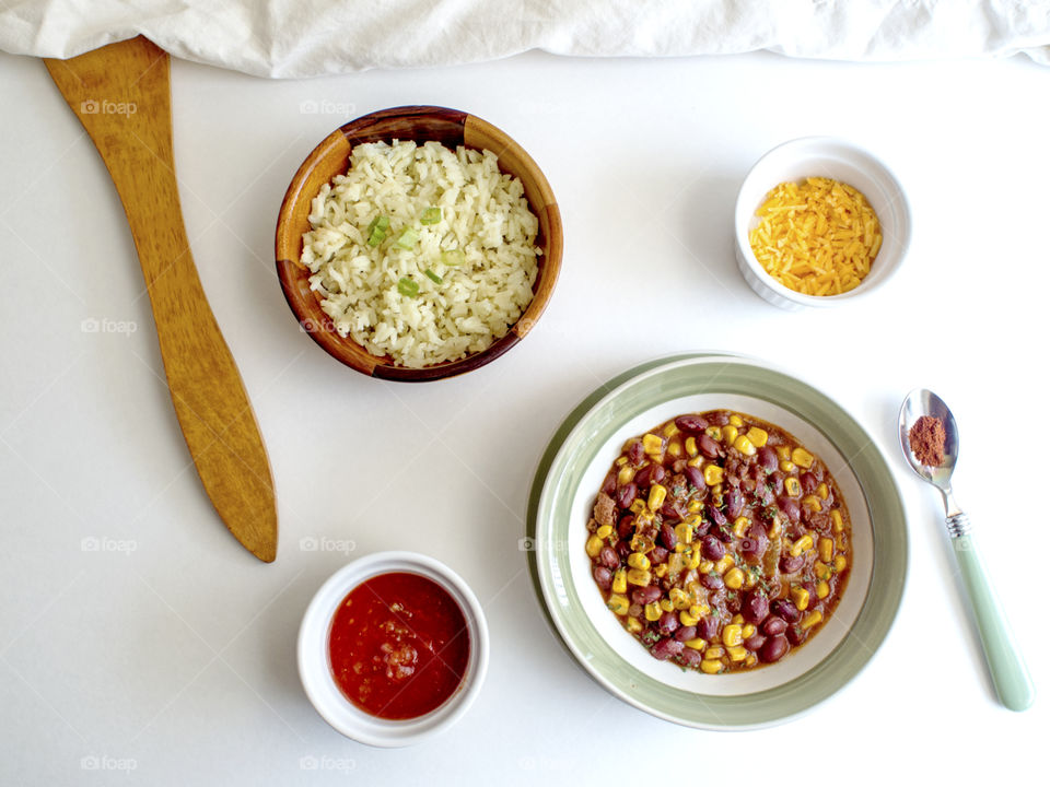 Bowl of chili with rice, cheese and salsa 