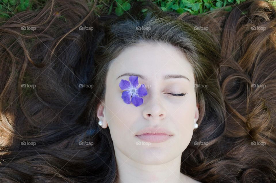 Portrait of a Beautiful Young Girl on Background of Daisies