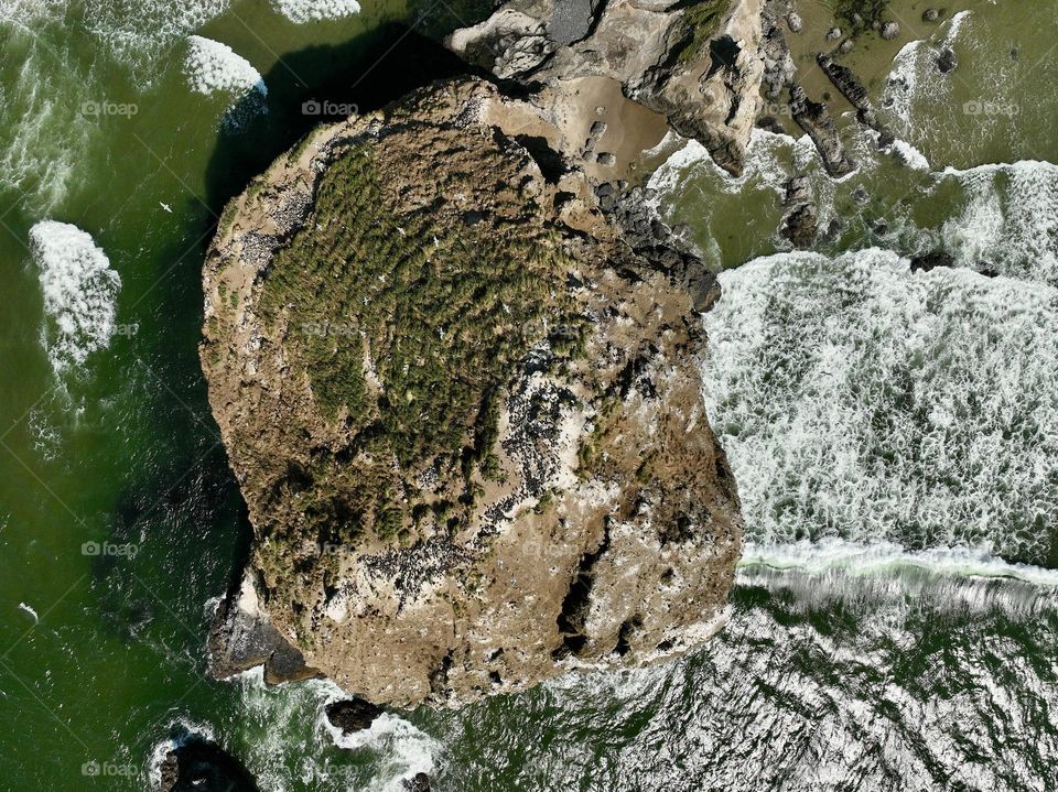 Haystack Rock standing tall amidst the serene beauty of Cannon Beach, where tide pools meet the endless horizon